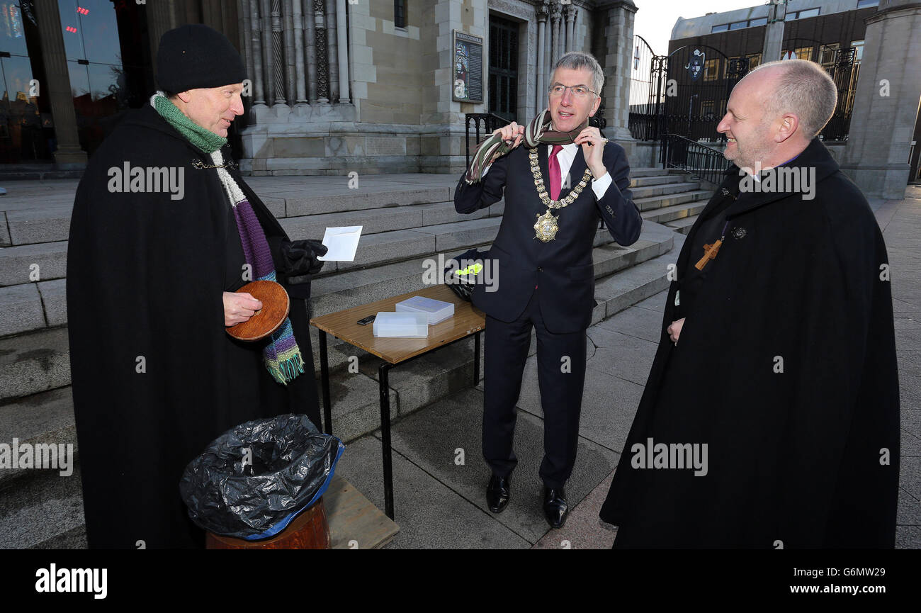 Signore Sindaco di Belfast, Mairtin o Muilleoir (centro), dopo aver fatto una donazione al Decano della Cattedrale di Sant'Anna di Belfast, don John Mann (a sinistra) con il Vescovo di Connor il Rt Rev. Alan Abernethy, Come il Dean ha iniziato un Babbo Natale nero sit-out carità vicino al sito di Venerdì bomba esplosione. Foto Stock