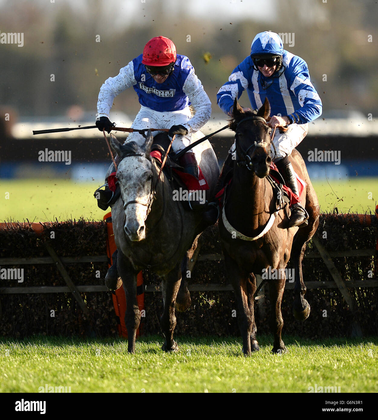 Mickie guidato da jockey Richard Johnson (a sinistra) va testa a testa con Cannon Fodder guidato da Marc Goldstein sull'ultima recinzione per andare avanti e vincere il William Hill - Scarica l'handicap di App Mares 'durante il giorno due del William Hill Winter Festival 2013 a Kempton Park Ippodromo Foto Stock