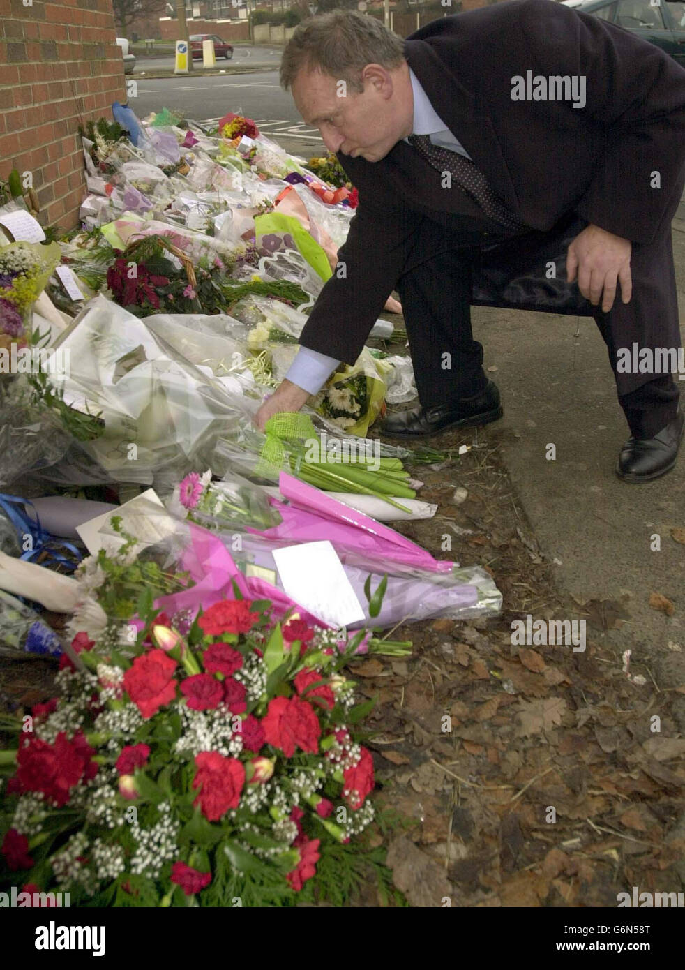 Il leader del Leeds City Council, Cllr Keith Wakefield, presenta un bouquet di fiori sulla scena delle riprese di PC Ian Broadhurst il giorno di Santo Stefano vicino a Dib Lane a Oakwood a Leeds. Il primo sospettato nella caccia di un pistolero che ha assassinato il trafficante il giorno di Santo Stefano è stato arrestato oggi dalla polizia armata in un tumuoso della mattina presto. Nathan Coleman, che si pensa sia americano, è stato arrestato dalla polizia di Northumbria in un hotel a Gateshead dopo una mancia da un membro del pubblico. Foto Stock