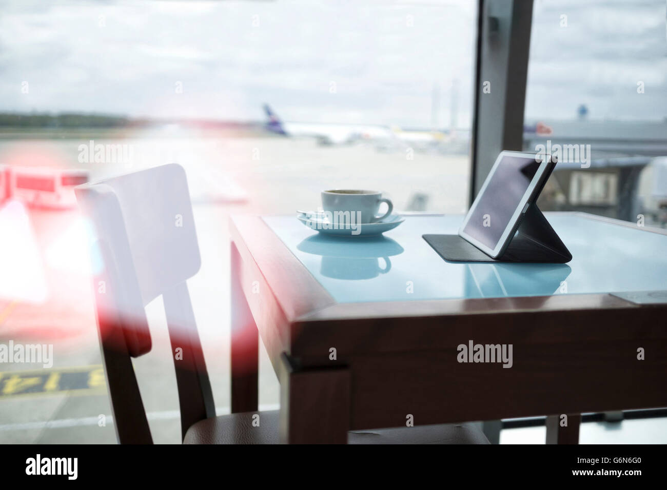 Tazza di caffè e tavoletta digitale sulla tabella all'aeroporto Foto Stock