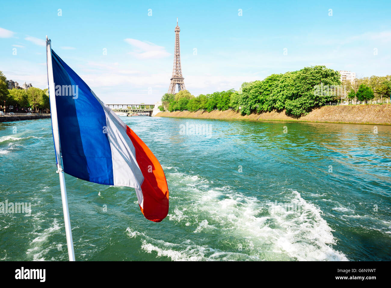 Francia, Parigi, bandiera francese sorvolano la Senna con la Torre Eiffel sullo sfondo Foto Stock