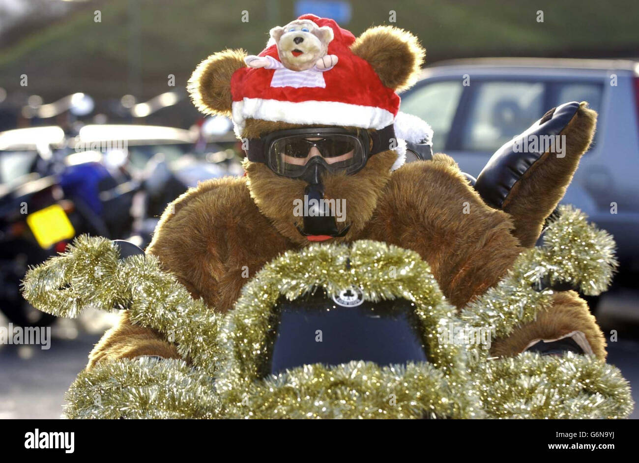 Un motociclista vestito con un abito da orsacchiotto si unisce a oltre un centinaio di motociclisti all'Ace Cafe, Brent, a nord di Londra, per consegnare regali di Natale ai bambini al Central Middlesex Hospital, St Mary's Hospital e St Thomas' Hospital. Foto Stock