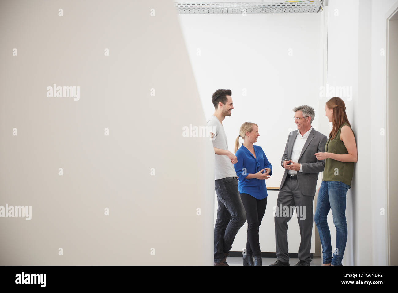 Un gruppo di uomini di affari che incontro nel corridoio di office Foto Stock