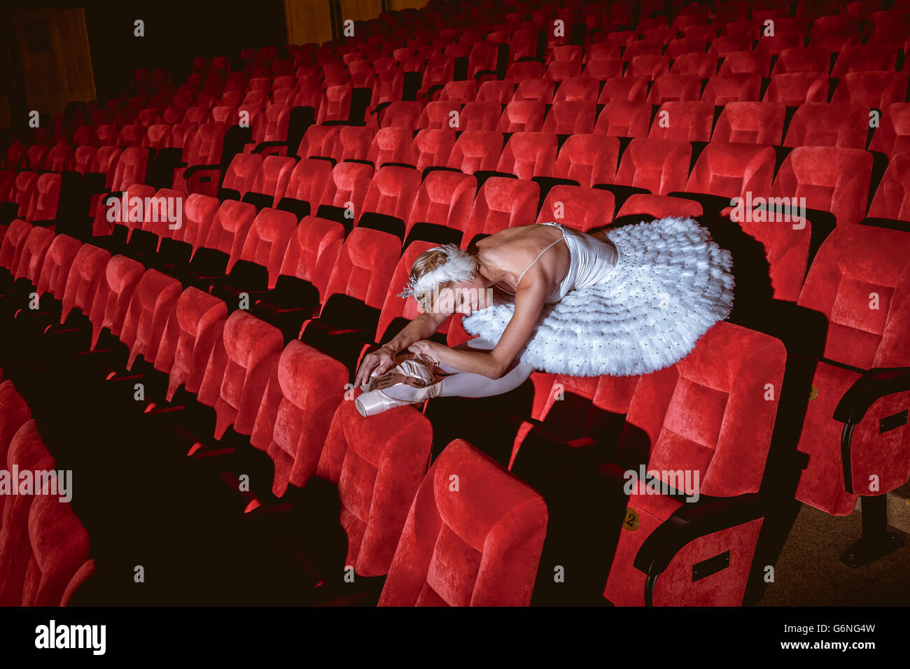 Ballerina seduta nel vuoto teatro auditorium Foto Stock