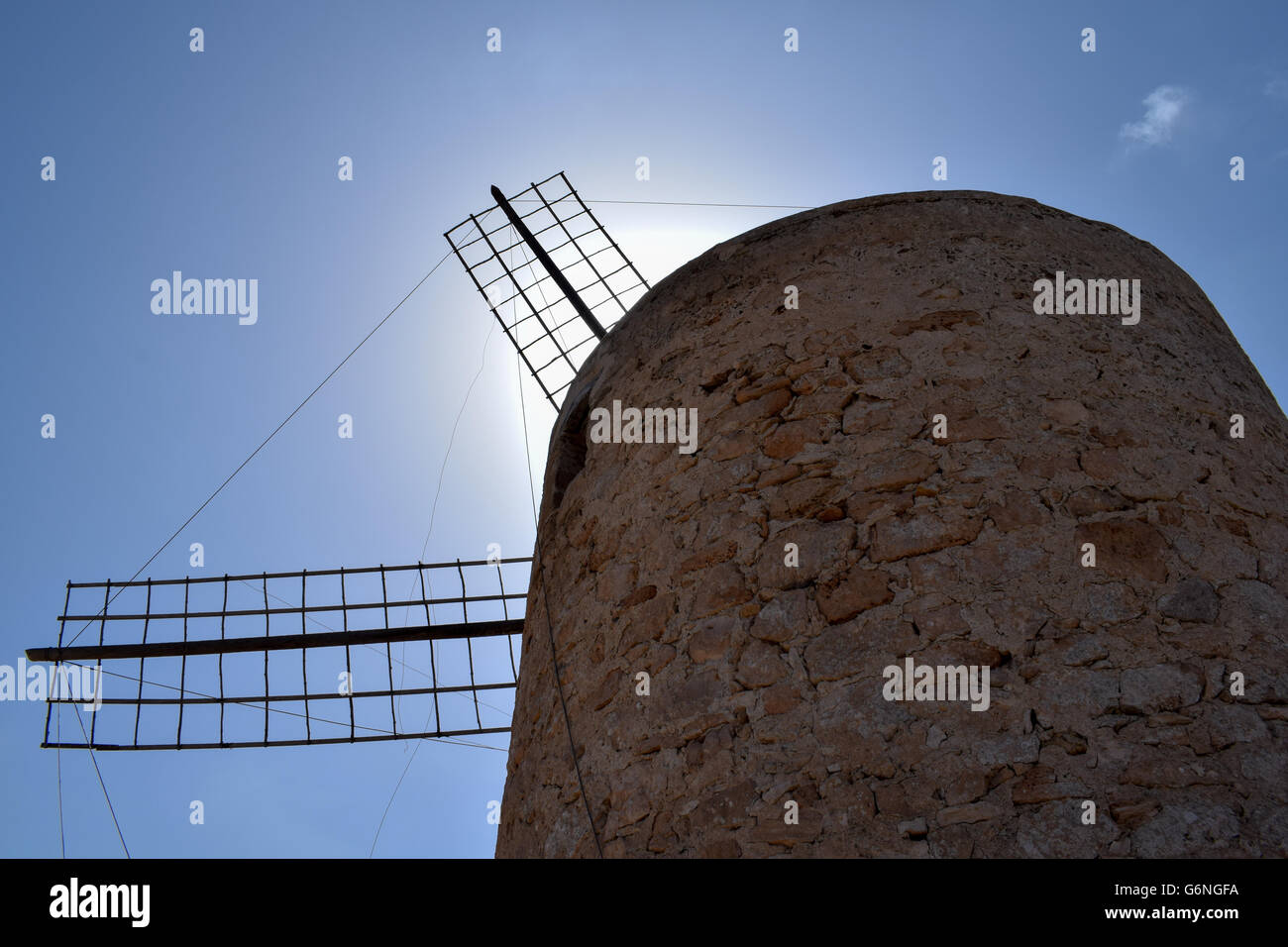 Basso angolo vista di mulini a vento di Formentera con il sole che tramonta dietro le vendite Foto Stock
