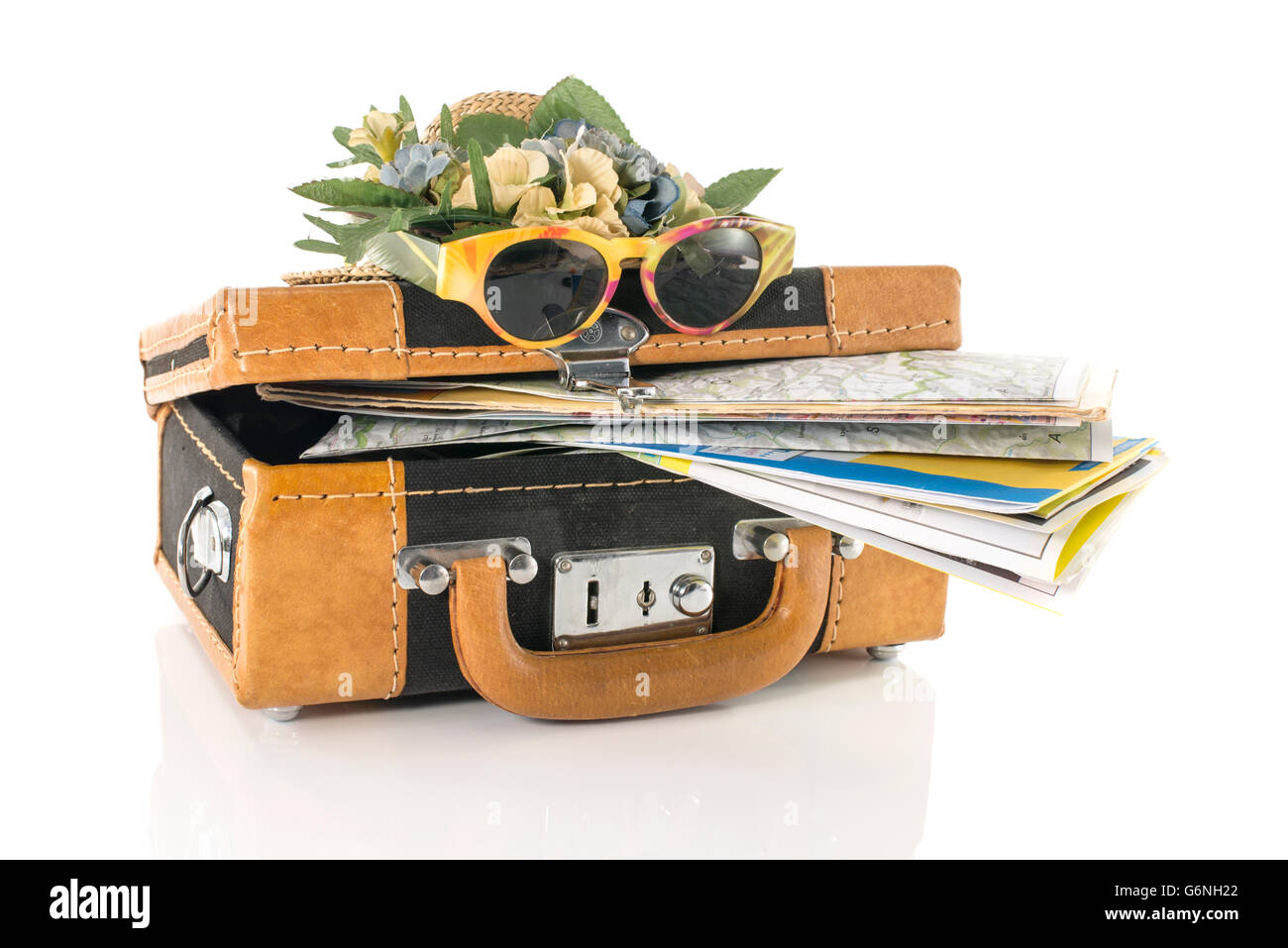 Pelle marrone valigia con mappe cappello e occhiali da sole per le destinazioni di viaggio isolato su bianco Foto Stock