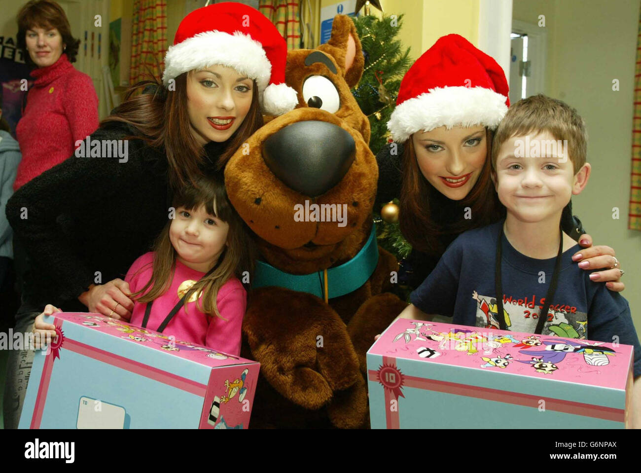 The Cheeky Girls with Eleanor Scott, 4, from Somerset, James Morrison, 6, Dal cane di Liverpool e cartone animato Scooby Doo durante una festa Winter Wonderland al Great Ormand Street Hospital tenuto dalla Cartoon Network. Foto Stock