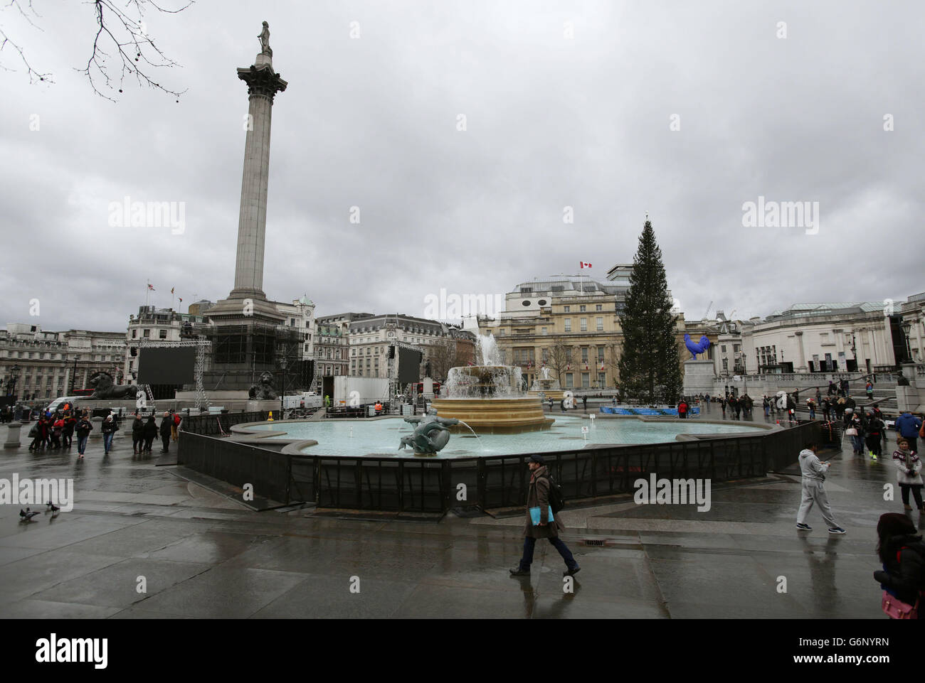 Barriere sono erette intorno alle fontane in Trafalgar Square durante la preparazione per la mostra di fuochi d'artificio di Capodanno, nel centro di Londra. Foto Stock