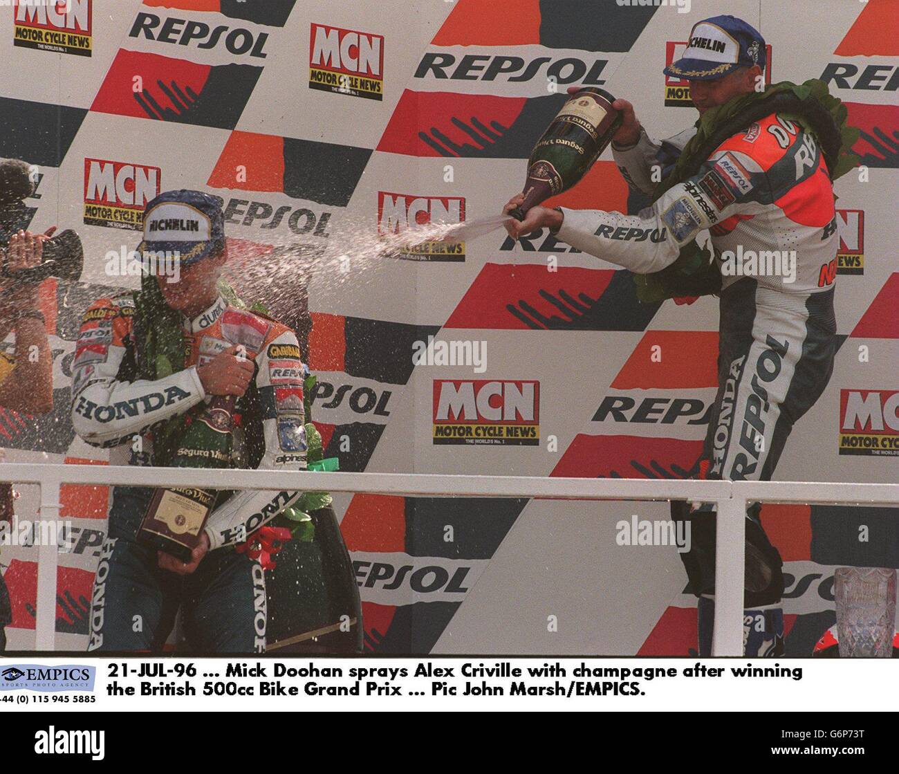 Mick Doohan spruzza Alex Criville con champagne dopo aver vinto il Gran Premio di Bike della 500cc britannica Foto Stock