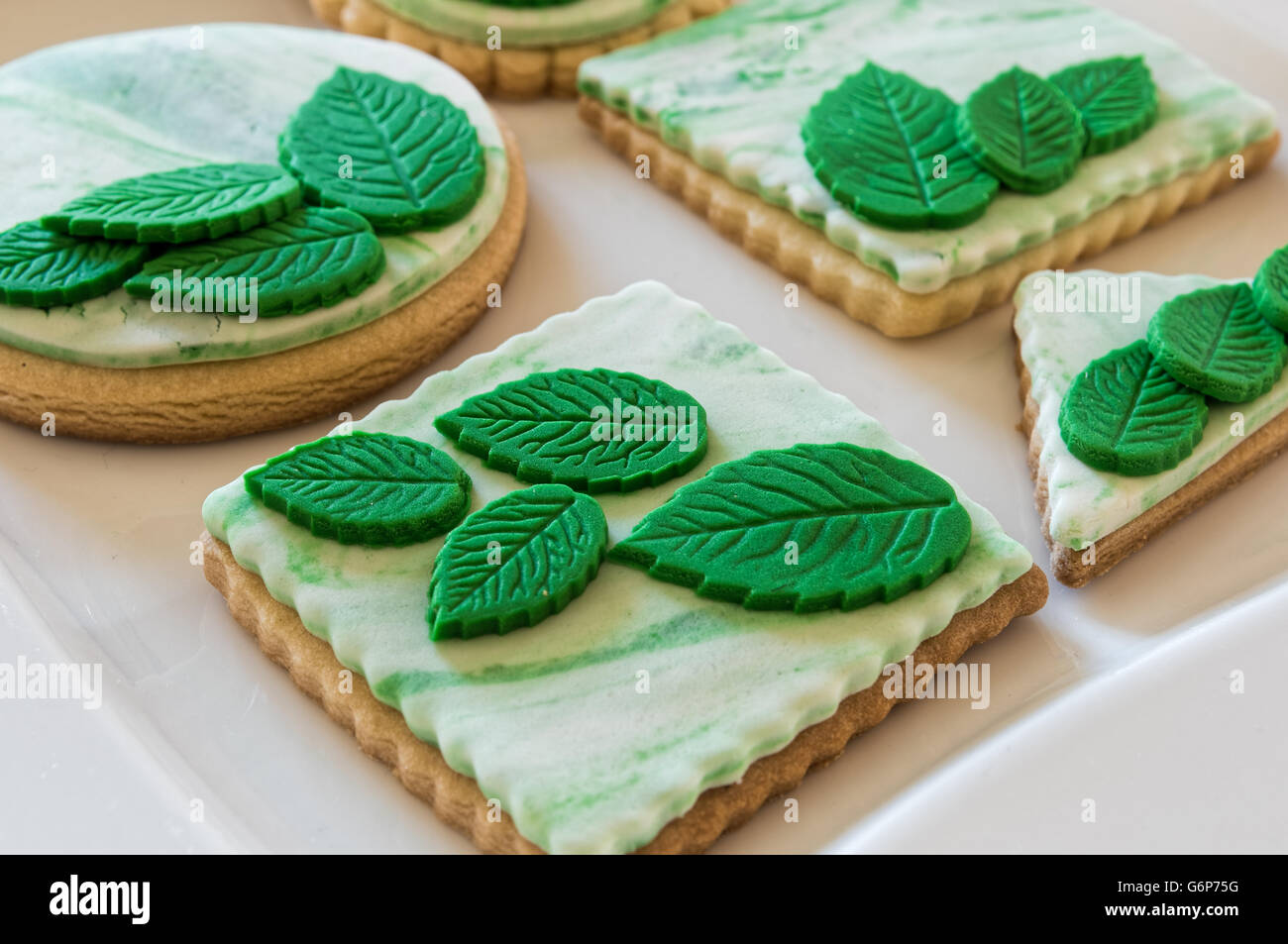 In casa bianco biscotti al burro, decorato con foglie di colore verde Foto Stock