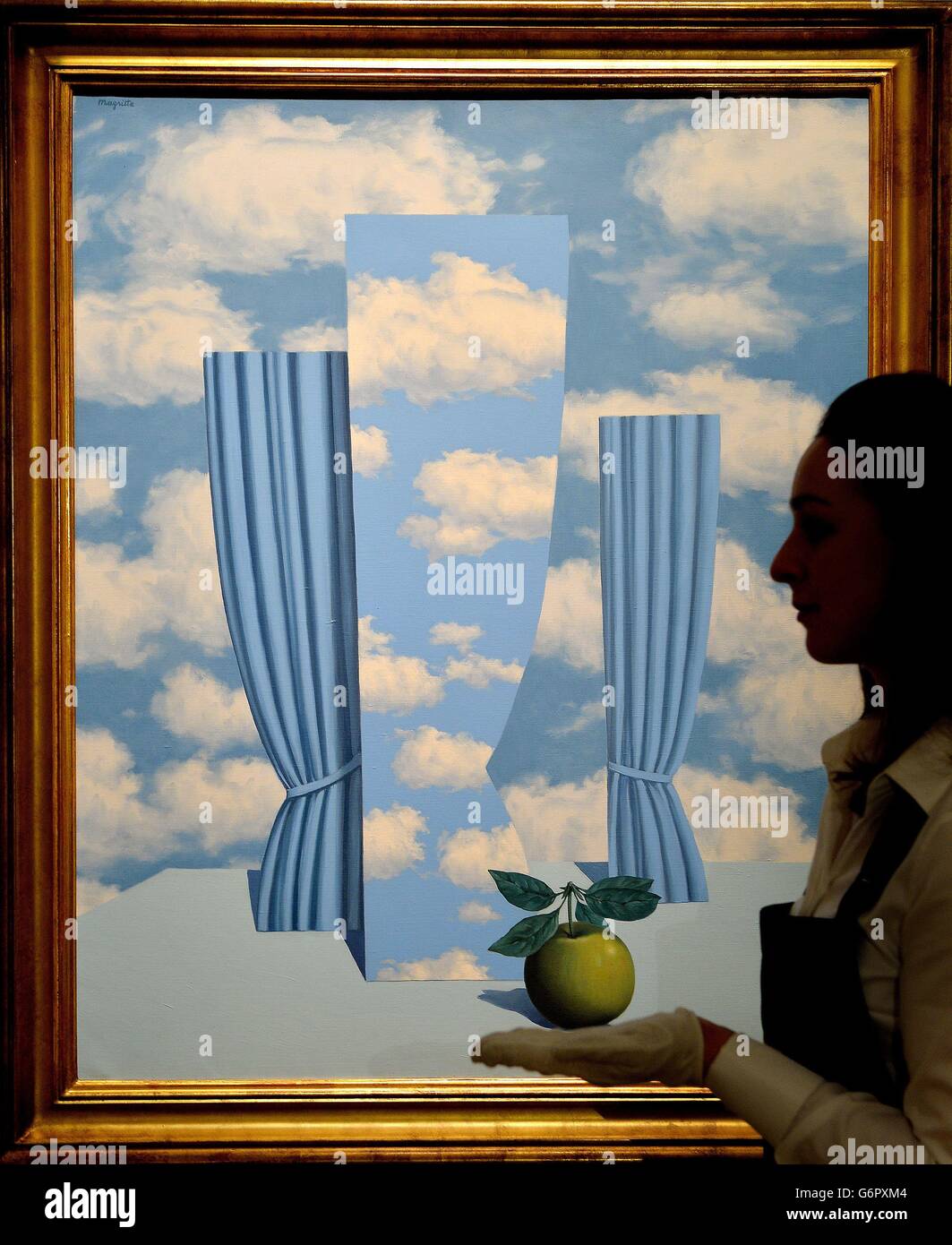 Una dipendente femminile di Sotheby's esamina il 'le Beau Monde' di Rene Magritte di Rene Magritte, presso il loro showroom nel centro di Londra, che si prevede di recuperare &libbra;4 milioni quando viene venduto durante la vendita di Impressionist, Modern e surreal Art della casa d'asta il mese prossimo. Foto Stock