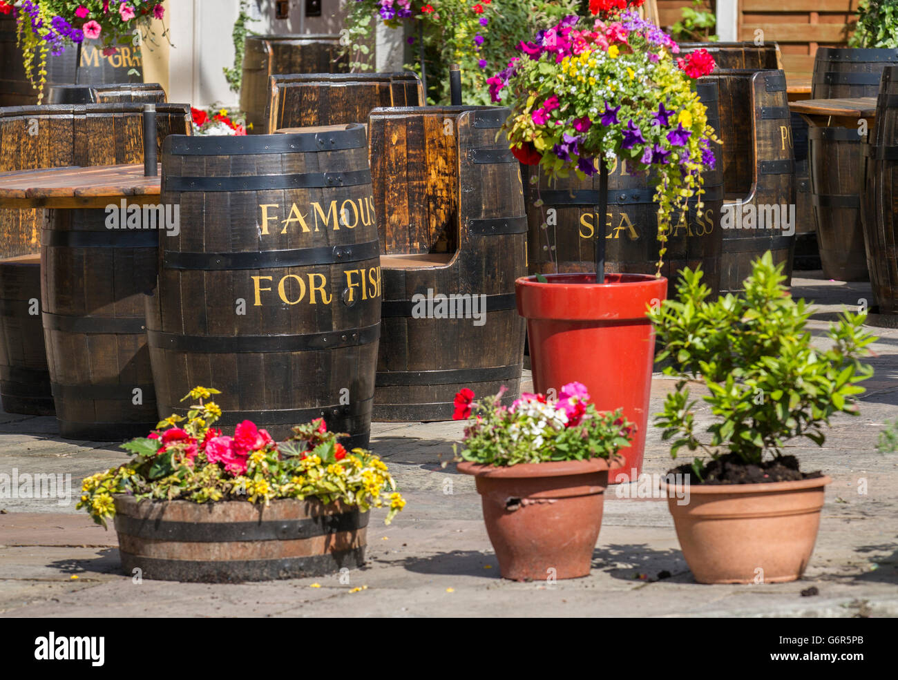Patio whiskey riciclati o whisky botti utilizzate come tavoli e sedie in un ristorante locale per cenare al-fresco. Southport, Regno Unito Foto Stock