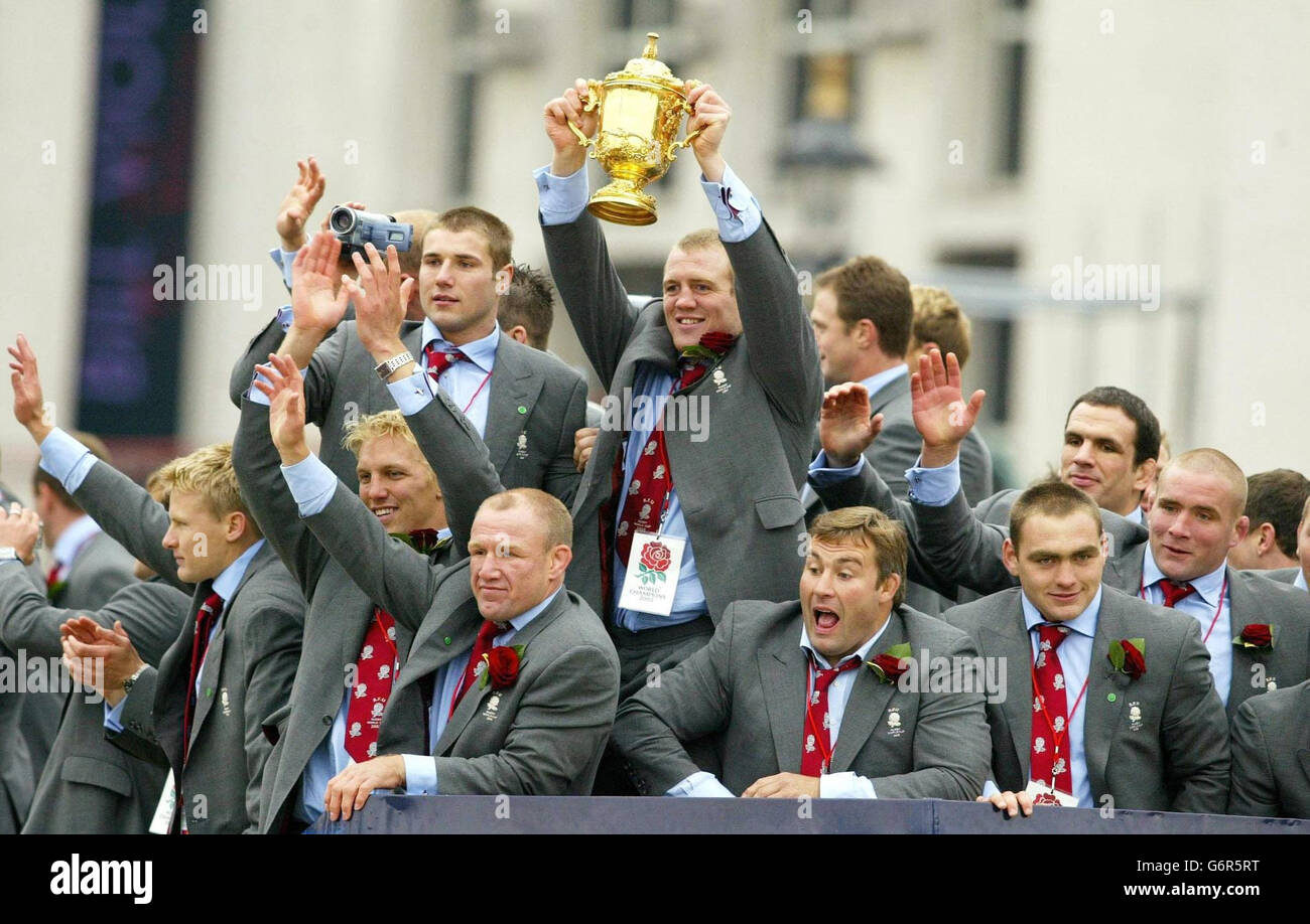 File della biblioteca del PA datato 08/12/2003 del Mike Tindall dell'Inghilterra che tiene aloft il trofeo di Webb Ellis fra i suoi compagni di squadra vincenti della Coppa del mondo. Il trofeo inglese della Coppa del mondo di rugby si è fatto a caccia di un jet giovedì 5 febbraio 2004, per il lancio di un tour di quattro mesi del paese. L'Inghilterra e il centro di Bath Mike Tindall accompagneranno il trofeo Webb Ellis in un jet Harrier che decollerà da RAF Wittering, Lincolnshire, e atterrà a RAF Cosford, Shropshire, per l'inizio della parata. Guarda la storia della PA SPORT Cup. PA Foto: Phil Noble. Foto Stock