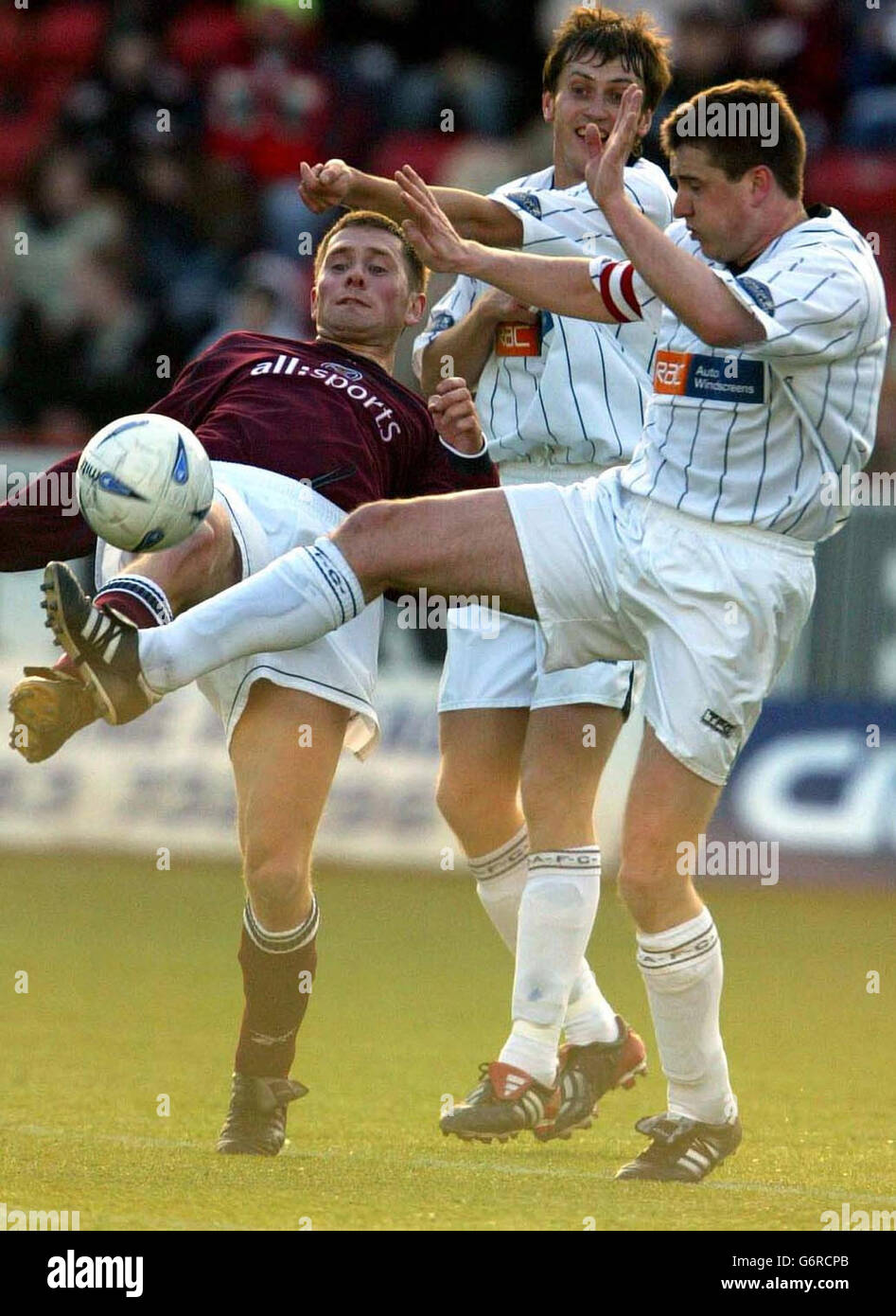Il giocatore di Dunfermline Scott Thompson (all'estrema destra) e Andrius Sherla (al centro) con Dennis Wyness of Hearts, durante la partita della Bank of Scotland Premier League all'East End Park, Dunfermline, sabato 28 febbraio 2004. Foto Stock