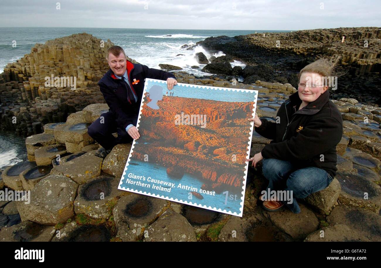 Il postino Alan Craig, dell'Ufficio postale di Bushman e Catherine Little, assistente dei servizi per i visitatori con il National Trust presso il Selciato del Gigante, Antrim Coast nell'Irlanda del Nord. La Royal Mail lancia un nuovo set di francobolli speciali - con i paesaggi dell'Irlanda del Nord - che vanno in vendita domani. Iniziarono la serie nel 2003 con la Scozia, e proseguiranno con il Galles nel luglio 2004, seguito dall'Inghilterra nel 2005. Foto Stock