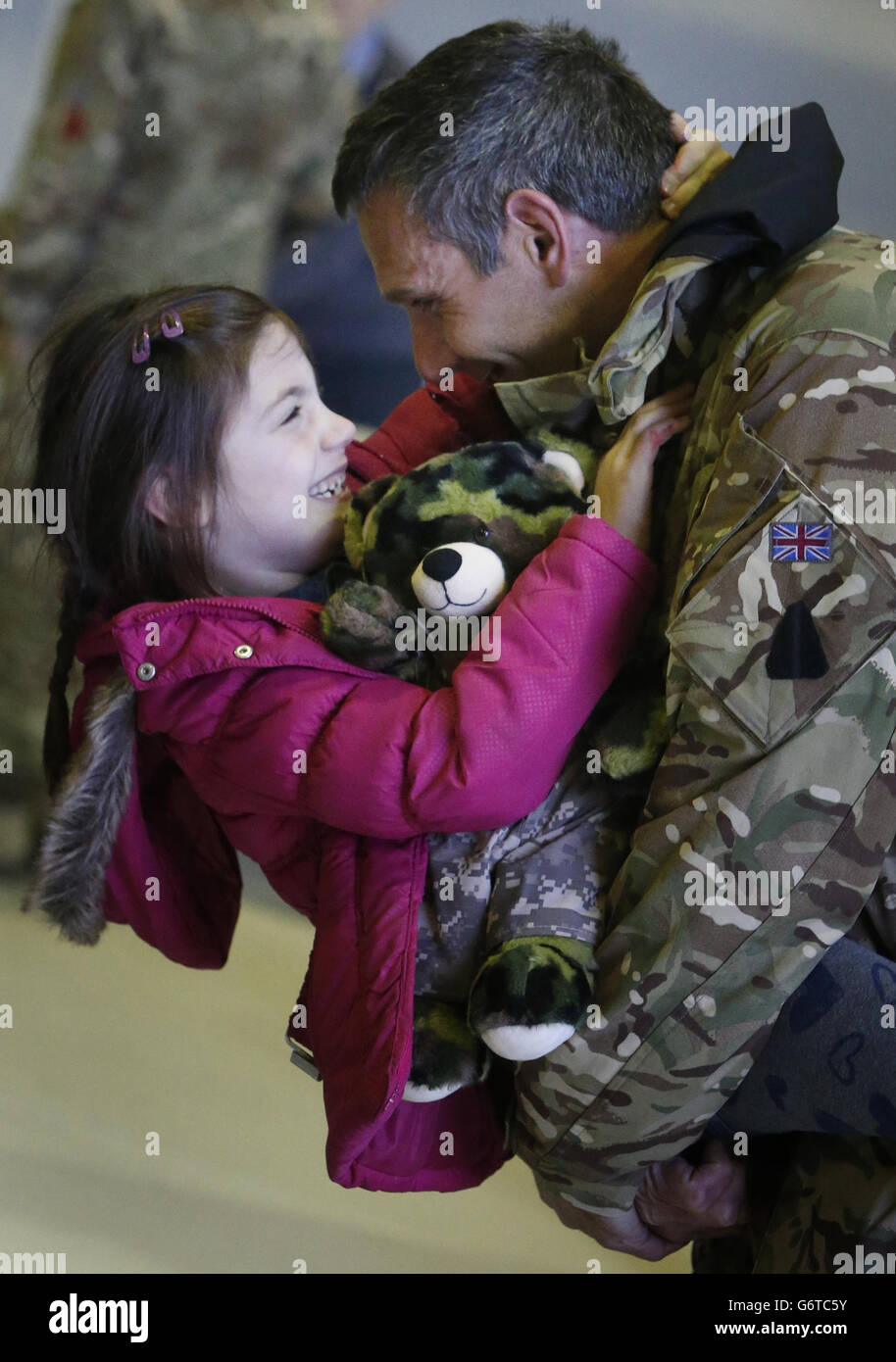 Il sergente Richard Hawley e sua figlia Aoife, di sei anni, come membri di 617 Squadron, i Dambusters, ritornano a RAF Lossiemouth, a Moray, dall'Afghanistan, prima di sciogliersi fino al 2016. PREMERE ASSOCIAZIONE foto. Data immagine: Martedì 4 febbraio 2014. L'unità verrà sciolta il 1° aprile come parte del progetto di tiraggio della forza di Tornado GR4, ma si riformerà nel 2016, prendendo la consegna del ''altamente avanzato'' Lightning II fighter. Lo squadrone partì per l'Afghanistan in ottobre, il suo schieramento finale per fornire ricognizione aerea alle forze di terra a guida afghana. Probabilmente è il più Foto Stock