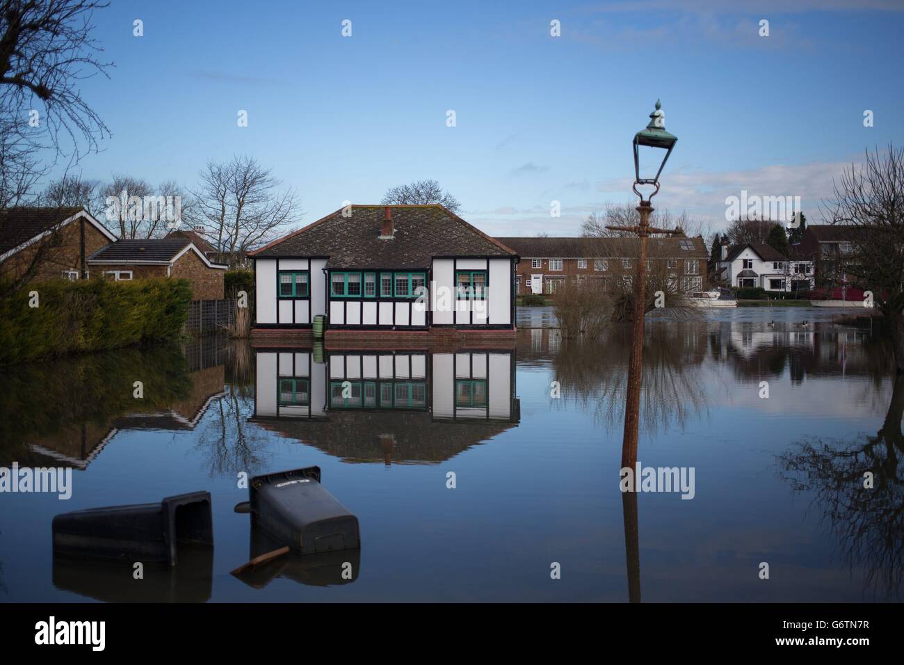 Una proprietà a Laleham Reach, Surrey continua ad essere circondato da acqua, in quanto il costo degli sconti fiscali del consiglio per le vittime delle inondazioni sarà coperto dal Tesoro, ha confermato David Cameron. Foto Stock