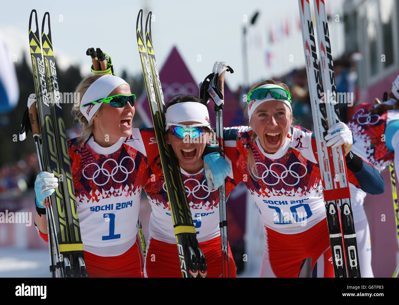 Giochi olimpici invernali di Sochi - giorno 15. Il norvegese Marit Bjoergen (centro) celebra la vittoria della Contea di Ladies 30 km Cross con Therese Johaug (a sinistra) e Kristin Stoermer Steira Foto Stock