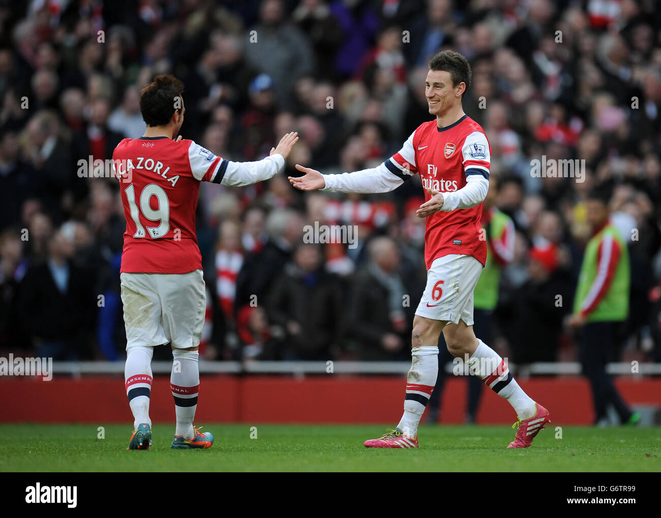 Laurent Koscielny dell'Arsenal (a destra) si congratula con i Santi Cazorla dell'Arsenal (a sinistra) dopo che ha segnato il quarto gol del suo lato del gioco Foto Stock