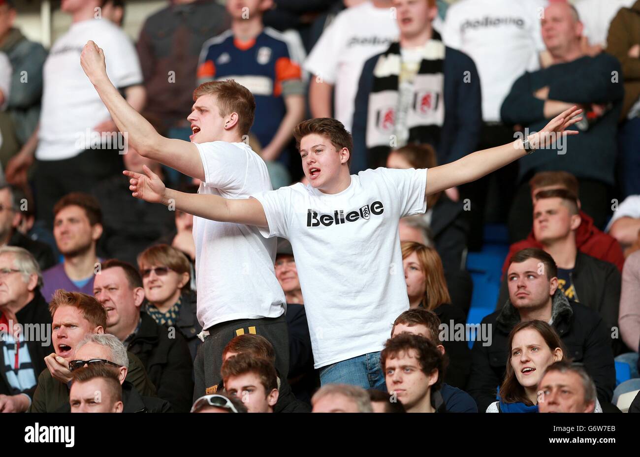I fan di Fulham in t-shirt 'Believe' celebrano il loro obiettivo negli stand Foto Stock