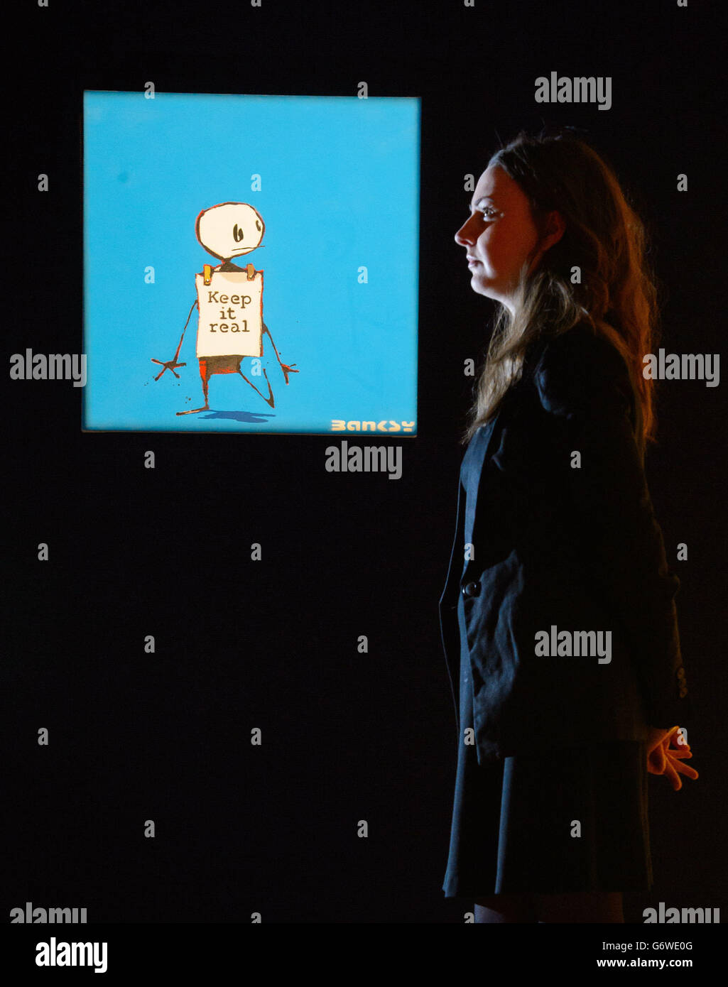 Un visitatore vede Banksy 'Keep IT Real' valore a &Acirc;&Pound;50,000 a &Acirc;&Pound;70,000, parte della vendita Bonhams 'Contemporary Edge', che si svolge il 4 marzo 2014. Foto Stock