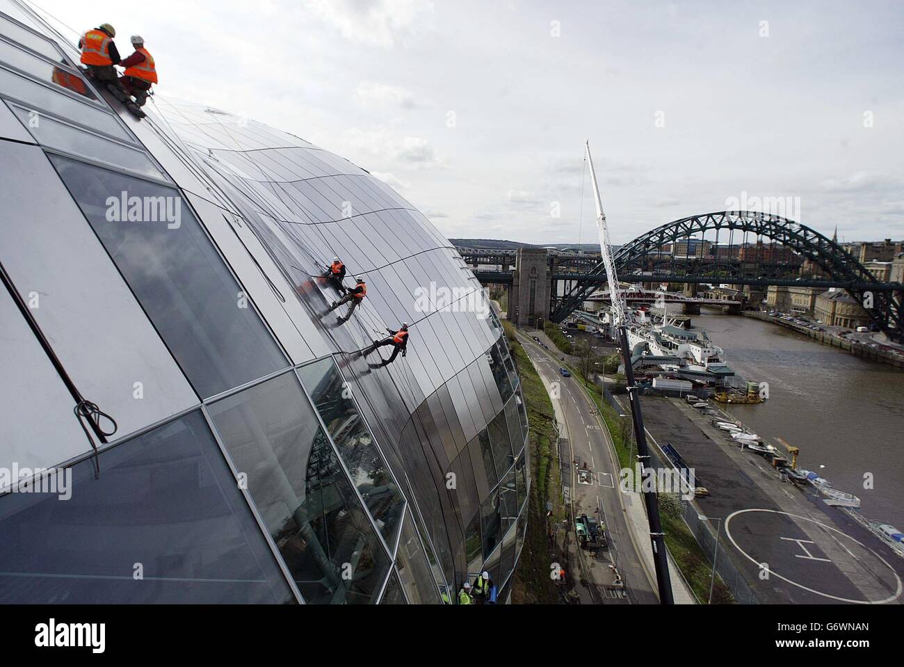 L'ultimo pannello del Sage Gateshead, che domina il rivitalizzato fiume Tyne sul versante di Tyneside, lentamente montato a lato dell'esclusivo edificio in vetro. Il Sage, che sarà uno dei locali musicali più individuali del paese, ha costato 70 milioni di euro per costruire. Lo spettacolare tetto curvo in acciaio, che pesa 750 tonnellate, è realizzato in 3,000 pannelli in acciaio inox e 250 pannelli in vetro. Foto Stock