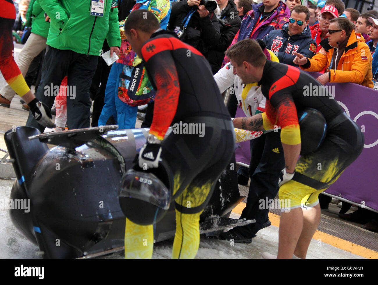 Il primo ministro russo Dmitry Medvedev (secondo in alto a sinistra) guarda il Bobsleigh maschile al Sanki Sliding Center, durante i Giochi Olimpici Sochi 2014 a Krasnaya Polyana, Russia. Foto Stock