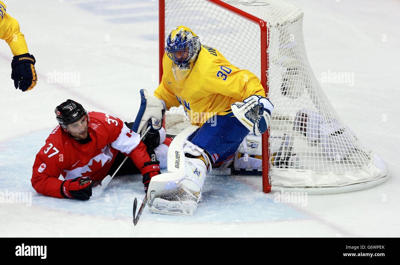 Giochi olimpici invernali di Sochi - giorno 16. Patrice Bergeron del Canada collide con Henrik Lundqvist della Svezia. Foto Stock