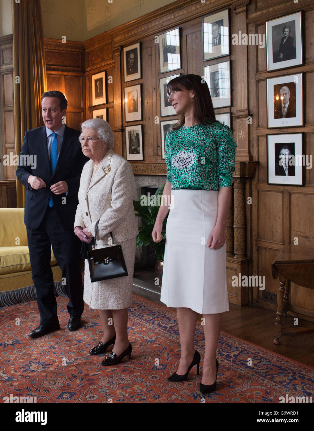 La regina Elisabetta II è mostrata fotografie di ex primi ministri a Chequers, dove lei e il duca di Edimburgo hanno pranzato con il primo ministro David Cameron e sua moglie Samantha. Foto Stock