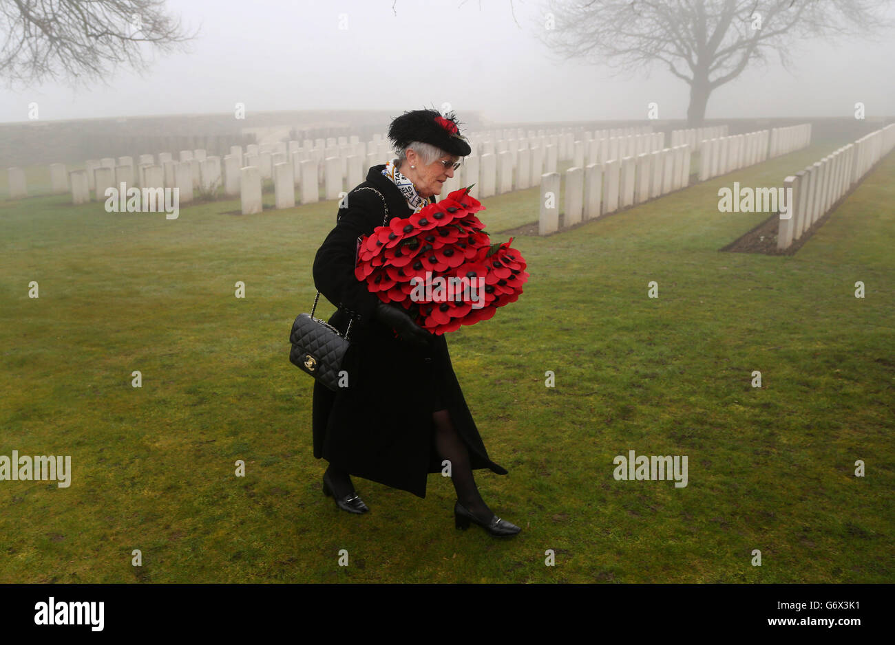 Una signora arriva al Commonwealth War Graves Commission Loos British Cemetery come 20 soldati sono reinterrati quasi 100 anni dopo che sono stati uccisi in azione nella Francia settentrionale. Foto Stock