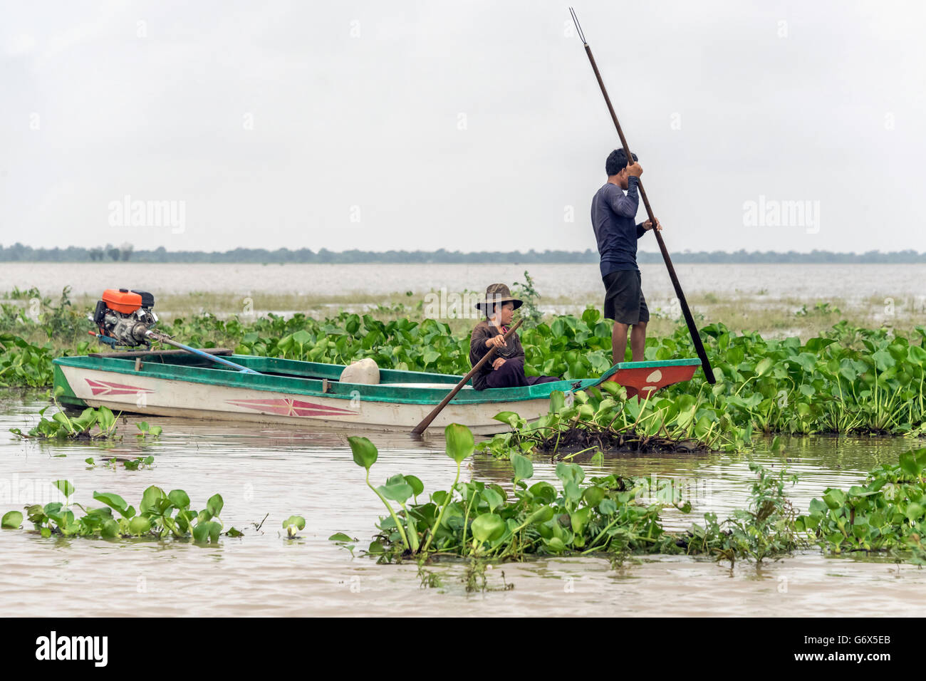 L uomo e la donna la pesca in acqua giacinti, stagione dei monsoni, Il Tonle Sap, Cambogia Foto Stock