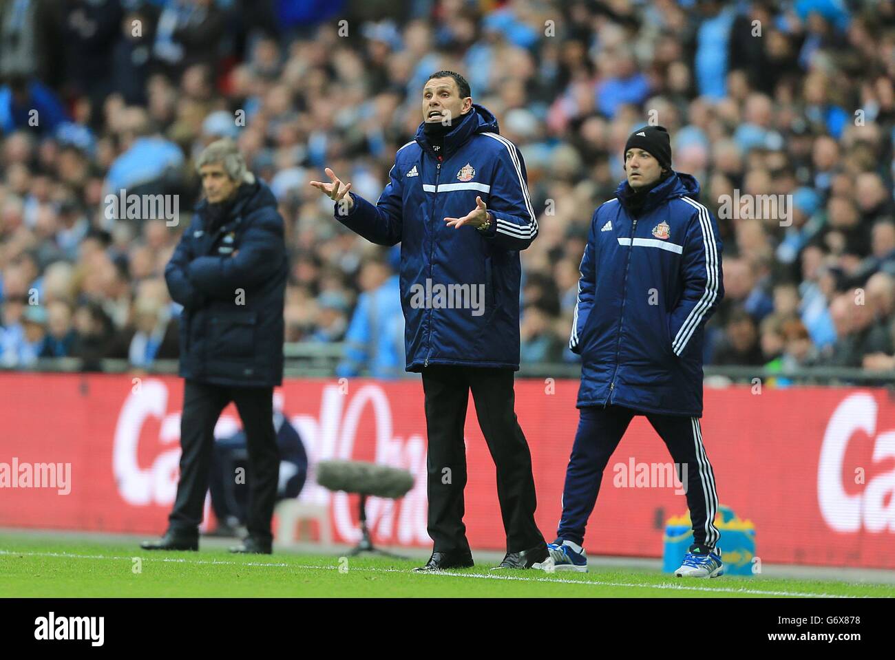 (Sinistra-destra) il responsabile della città di Manchester Manuel Pellegrini, il responsabile della Sunderland Gus Poyet e l'assistente Mauricio Tarco (destra) sulla linea di contatto. Foto Stock