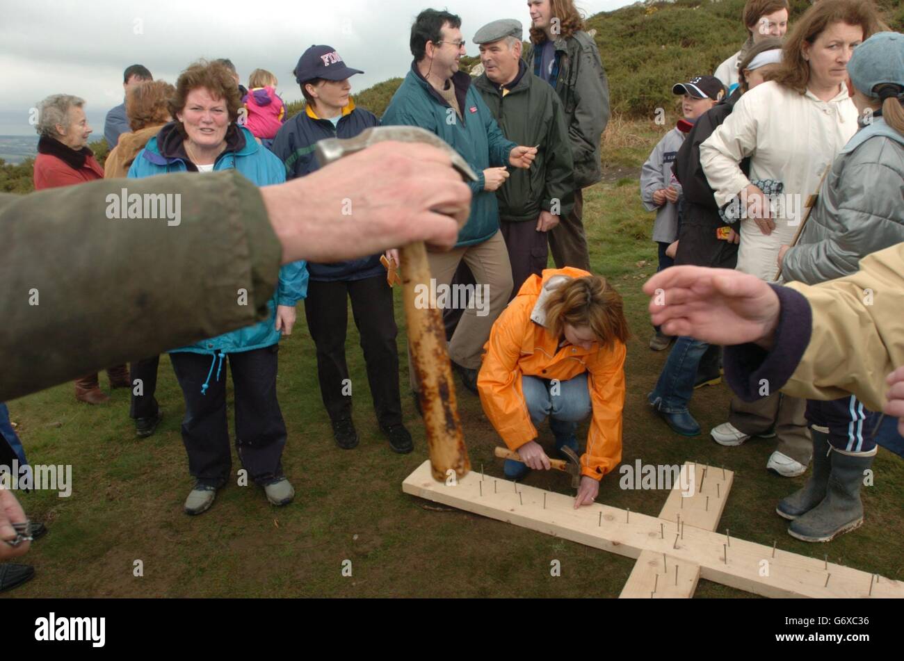 Pellegrini dalla nostra Signora Regina della Pace Chiesa, martellare unghie in una croce di legno in cima a Bray Head Point, Co Wicklow, dopo aver preso le curve per portarlo su la montagna, riprominendo la Passione di Cristo per il Venerdì Santo. Foto Stock
