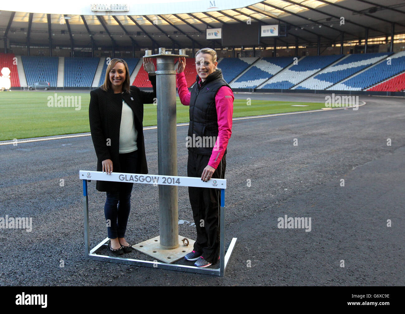 Ambasciatori dei Commonwealth Games Jessica Ennis-Hill (a sinistra) e medaglia d'argento del Commonwealth, Eilidh Child durante la fotocellula a Hampden Park, Glasgow. PREMERE ASSOCIAZIONE foto. Data immagine: Mercoledì 12 marzo 2014. Hampden Park, di solito sede della nazionale scozzese e delle finali della coppa nazionale, ha chiuso le sue porte lo scorso anno, mentre il lavoro ha iniziato a installare una pista da corsa. Gli scavatori sono stati introdotti per rimuovere il manto erboso dello stadio - alcuni dei quali sono stati presentati ai membri dell'esercito Tartan - e sono stati messi in atto palafitte in acciaio per sollevare la superficie di quasi due metri per creare la larghezza e la lunghezza Foto Stock