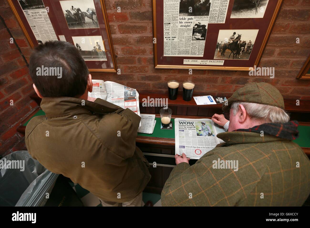 I racegoers controllano la forma prima di correre nell'Arkle Bar il giorno delle Signore, durante il festival di Cheltenham. Foto Stock