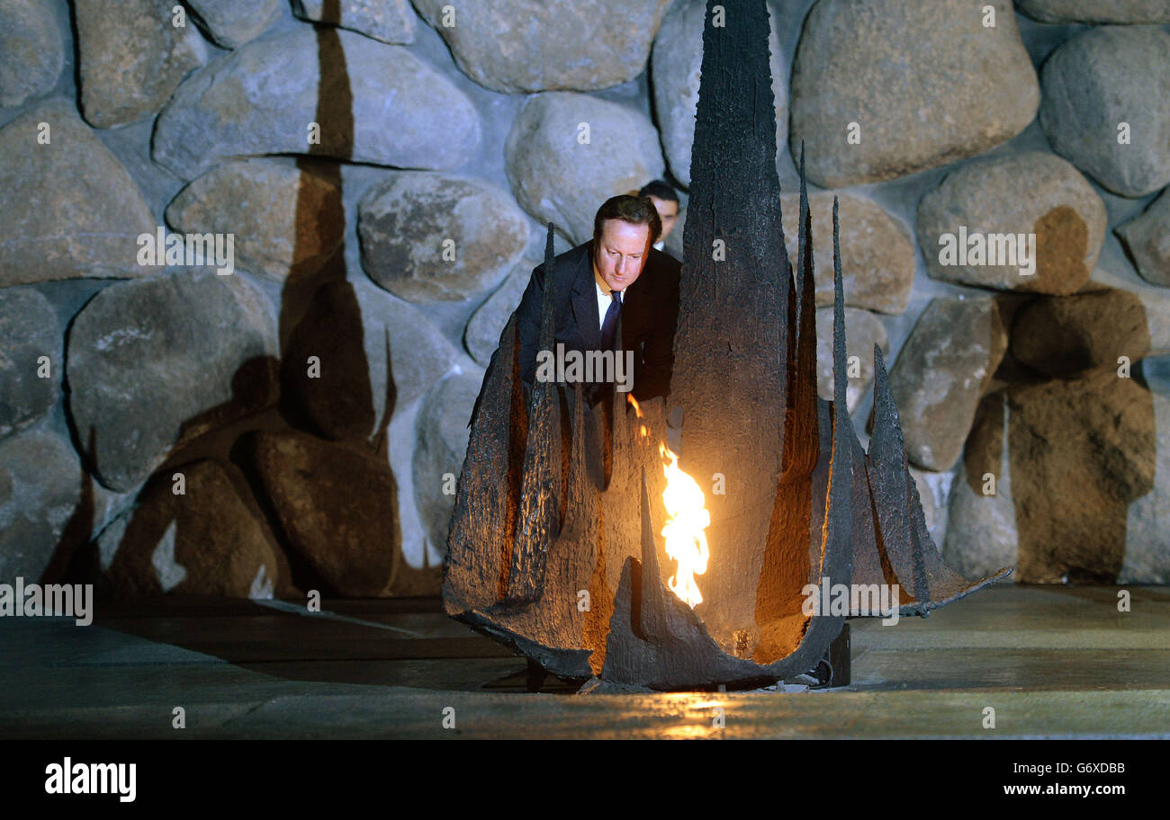 Il primo ministro David Cameron riaccende la fiamma eterna per i ricordi delle vittime dell'olocausto al museo dell'olocausto, Yad Vashem a Gerusalemme, Israele. Foto Stock