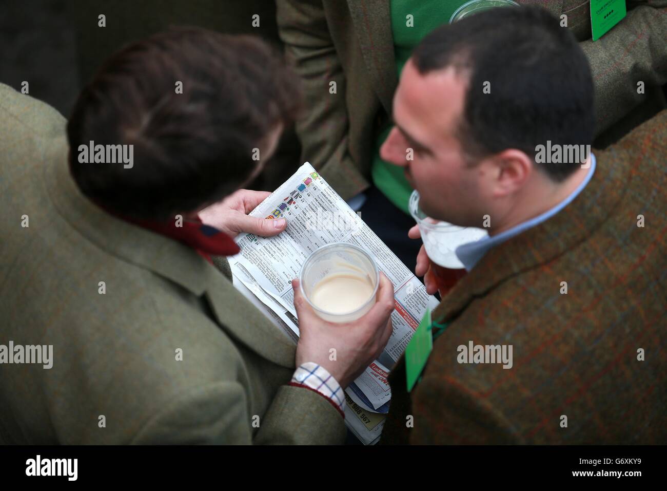 Corse di cavalli - Festival di Cheltenham 2014 - giorno di San Patrizio - Ippodromo di Cheltenham. I Racegoers controllano la carta il giorno di San Patrizio, durante il Festival di Cheltenham. Foto Stock