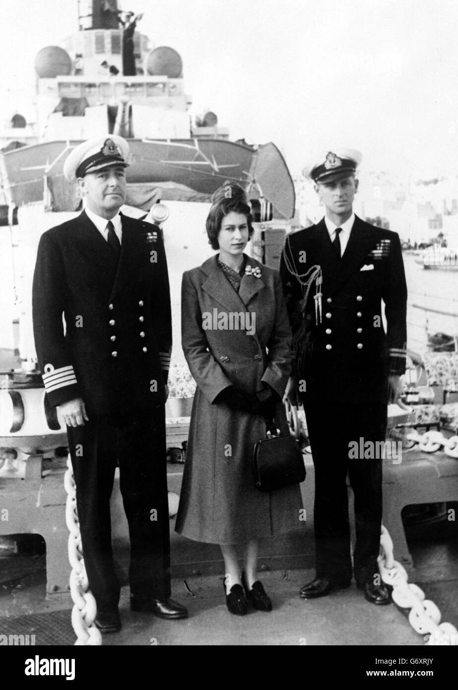 Il Duca di Edimburgo e il Capitano John Edwin Home McBeath DSO, DSC, RN (a sinistra), posa con la Regina Elisabetta II per una fotografia su HMS Chequers, durante la visita del giorno di Santo Stefano al cacciatorpediniere che il Duca sta attualmente servendo. Foto Stock