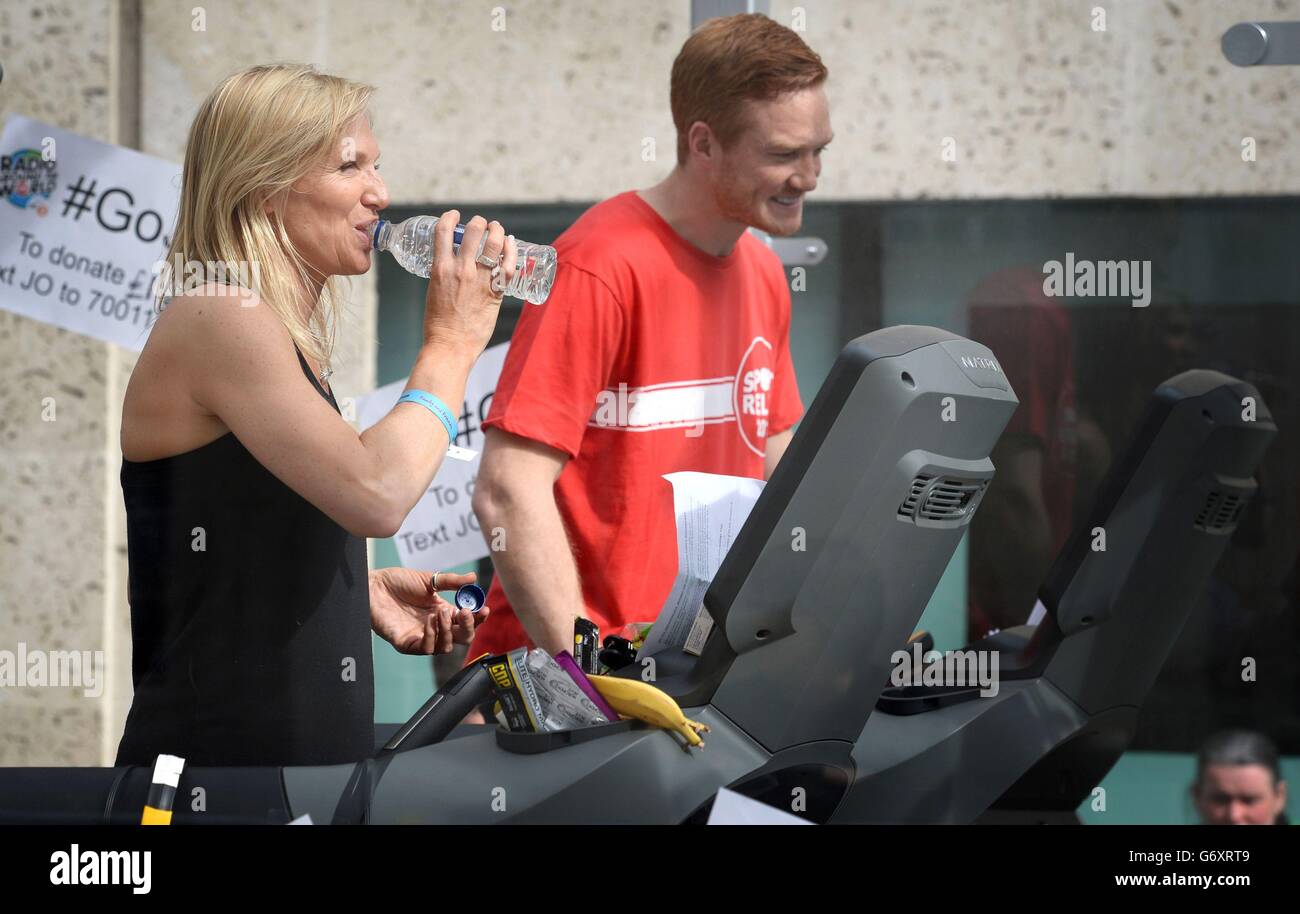 Radio 2 presentatore Jo Whiley, con Greg Rutherford, come Whiley sta partecipando alla sfida di rilievo di sport su un tapis roulant, in una scatola di perspex, fuori BBC Broadcasting House per 26 ore. Foto Stock