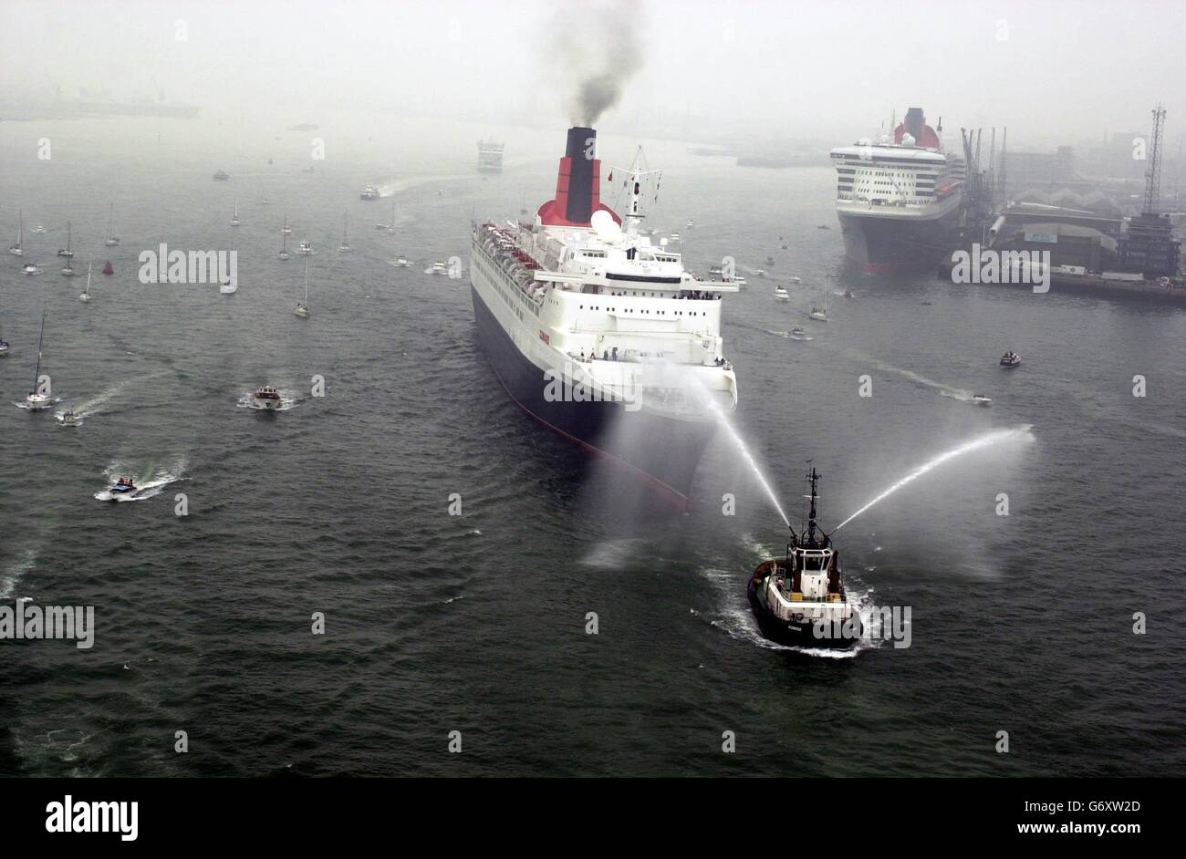 La QE2 oltrepassa la QM2 a Southampton. La fine di un'era in crociera è stata segnata oggi in una cerimonia che ha coinvolto il QE2 e il nuovo superliner di Cunard, la regina Mary 2 da 150,000 tonnellate (QM2). Alla cerimonia, alla presenza del vice primo ministro John Prescott, lo status di ammiraglia di Cunard passava dal QE2 di 35 anni ai 540 milioni di QM2, ufficialmente nominati dalla Regina nel gennaio di quest'anno. Foto Stock