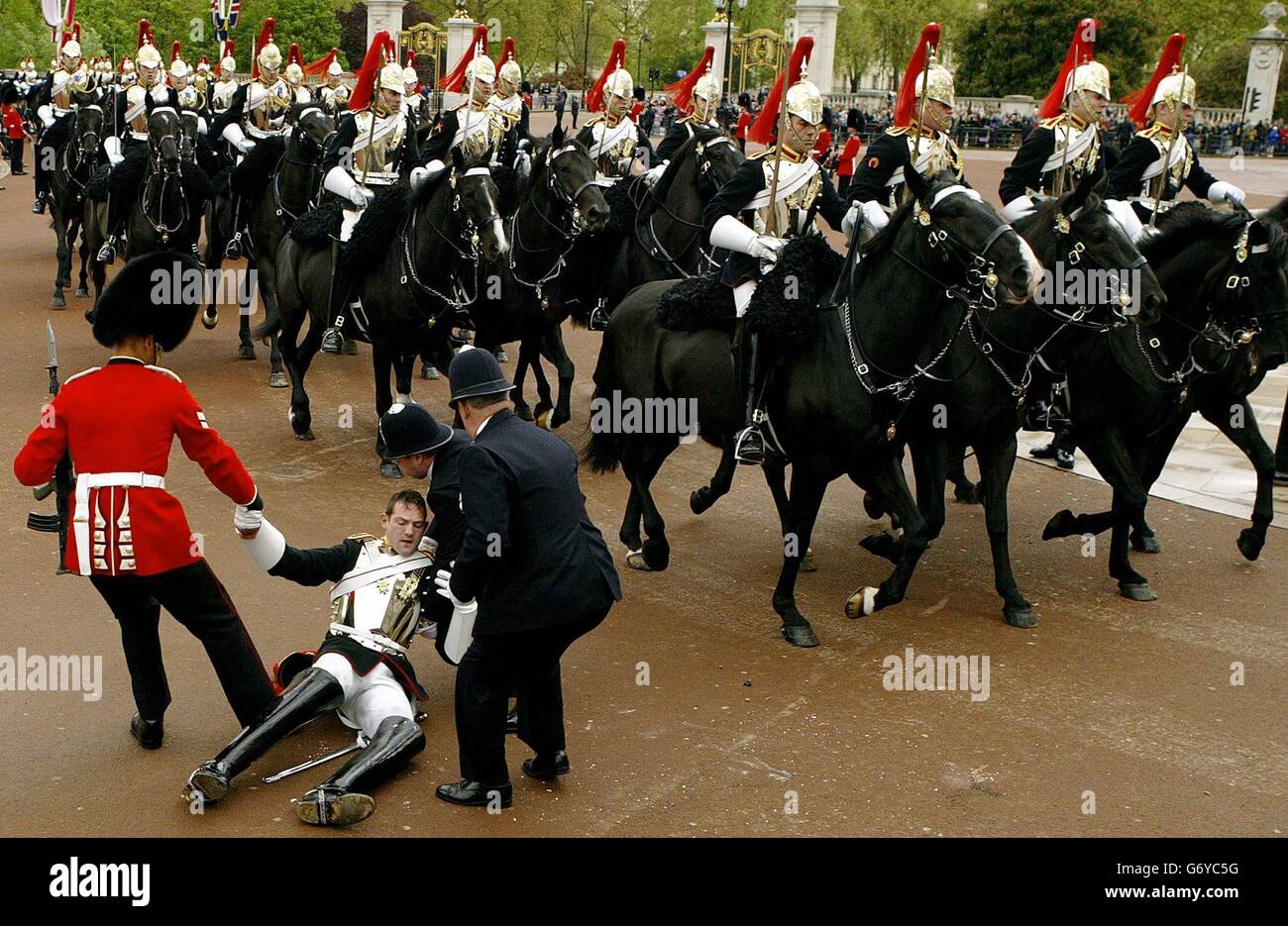 Un cavalleresco dei Blues and Royals (HCMR) viene gettato dal suo cavallo di fronte a Buckingham Palace durante la processione del presidente polacco Aleksander Kwasniewski e della regina. Kawsneiwski è in visita di Stato di due giorni in Gran Bretagna. Foto Stock