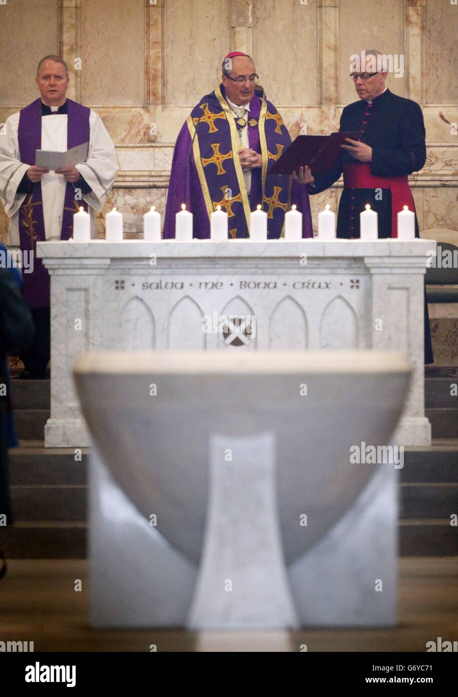 Dieci candele sono accese per rappresentare le dieci persone che sono morte nel crollo dell'elicottero di Clutha, durante un servizio commemorativo condotto dall'arcivescovo Philip Tartaglia (centro) nella Cattedrale di St Andrew a Glasgow. Foto Stock
