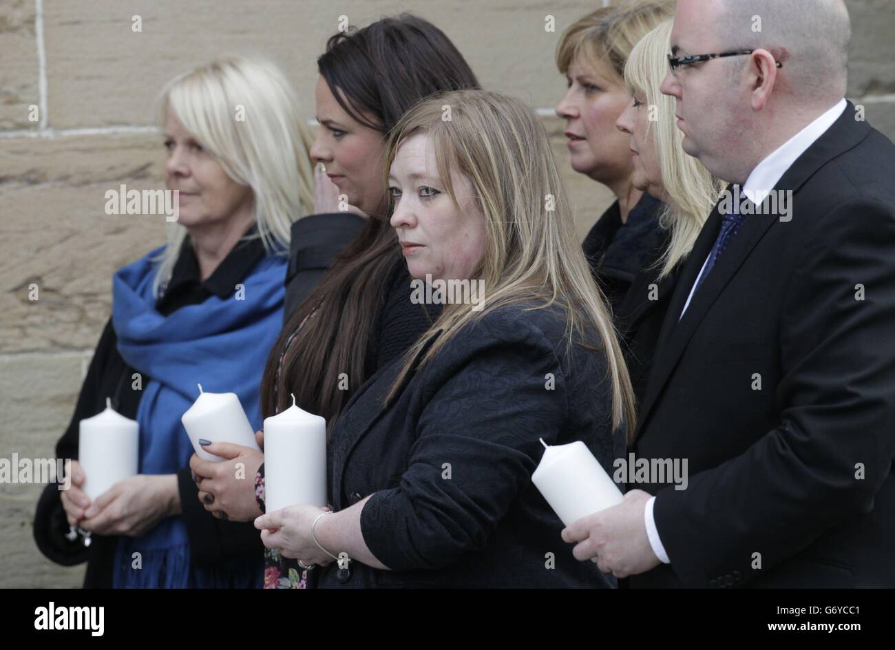 I membri della congregazione (nomi non conosciuti) hanno una candela davanti ad un servizio commemorativo dove dieci candele sono state accese per le dieci persone che sono morte nel crash dell'elicottero di Clutha, nella Cattedrale di St Andrew a Glasgow, Scozia. Foto Stock