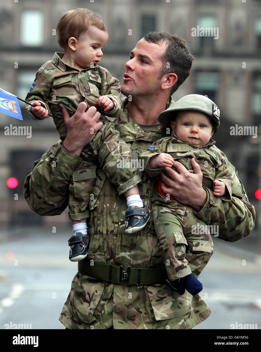 Trooper Colin qua della Royal Scots Dragoon Guards con il suo figlio di un anno Harly qua (a sinistra) e il nipote di sei mesi Colden McFarlane dopo una parata di ritorno per le strade di Glasgow, la parata segna il ritorno del reggimento da uno schieramento di sei mesi a Kabul, Afghanistan. Foto Stock