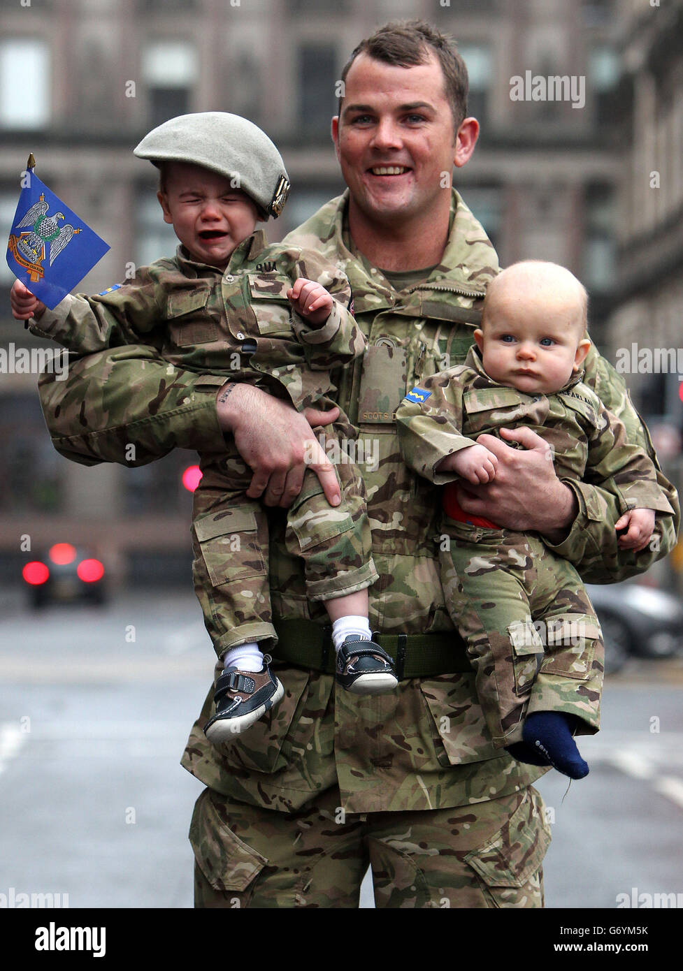 Trooper Colin qua della Royal Scots Dragoon Guards con il suo figlio di un anno Harly qua (a sinistra) e il nipote di sei mesi Colden McFarlane dopo una parata di ritorno per le strade di Glasgow, la parata segna il ritorno del reggimento da uno schieramento di sei mesi a Kabul, Afghanistan. Foto Stock