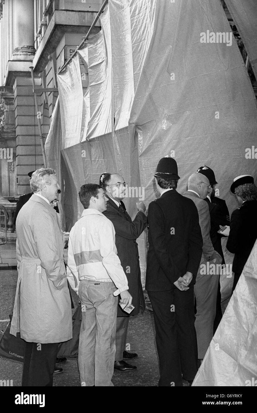 Un certo numero di impiegati si rivolgono alla barriera di strada fuori St James's Square, Londra, sperando di raggiungere i loro uffici all'interno e intorno all'area dell'ufficio del popolo libico assediato. Foto Stock