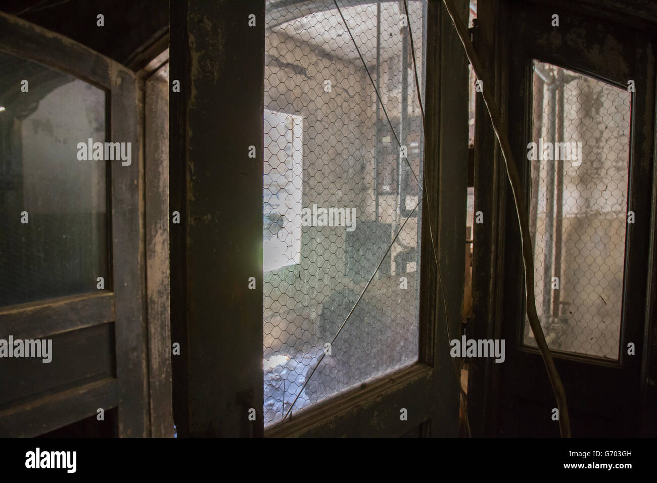 Grunge immagine della sala macchine attraverso il vetro rotto in porta. Foto Stock