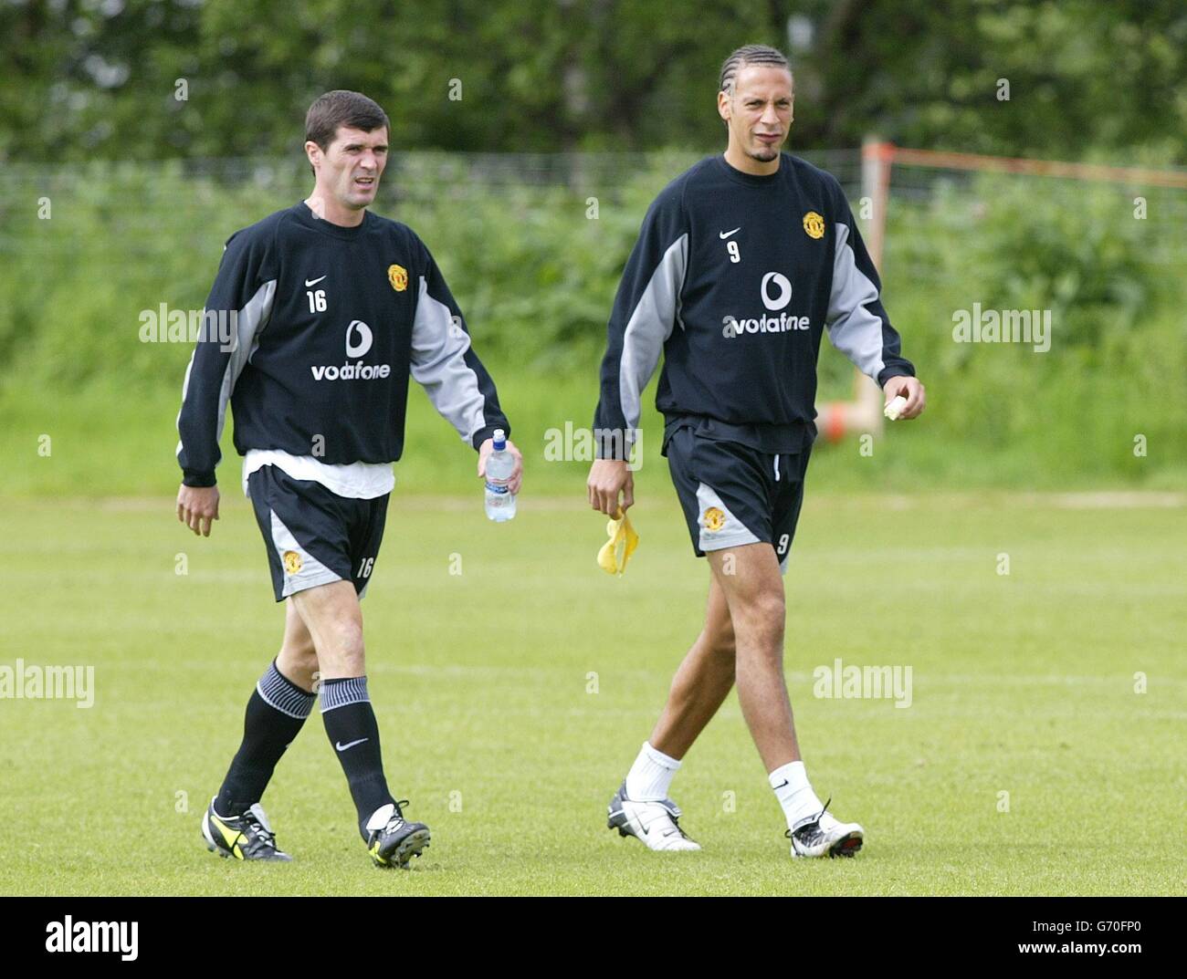 Roy Keane e Rio Ferdinand del Manchester United arrivano per una sessione di allenamento al Carrington Training Center del team, prima della finale della fa Cup contro Millwall di sabato. Foto Stock