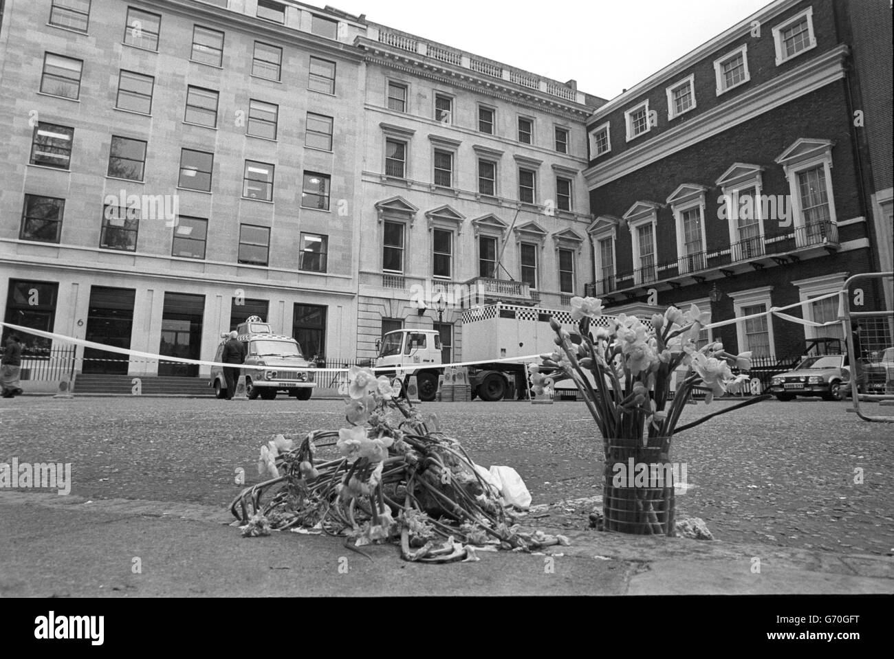Tributi floreali nel luogo in cui WPC Yvonne Fletcher è stato girato fuori da St James's Square a Londra il 17 aprile. A seguito di una ricerca approfondita dell'edificio e delle aree circostanti, è in corso una grande operazione di pulizia. Foto Stock