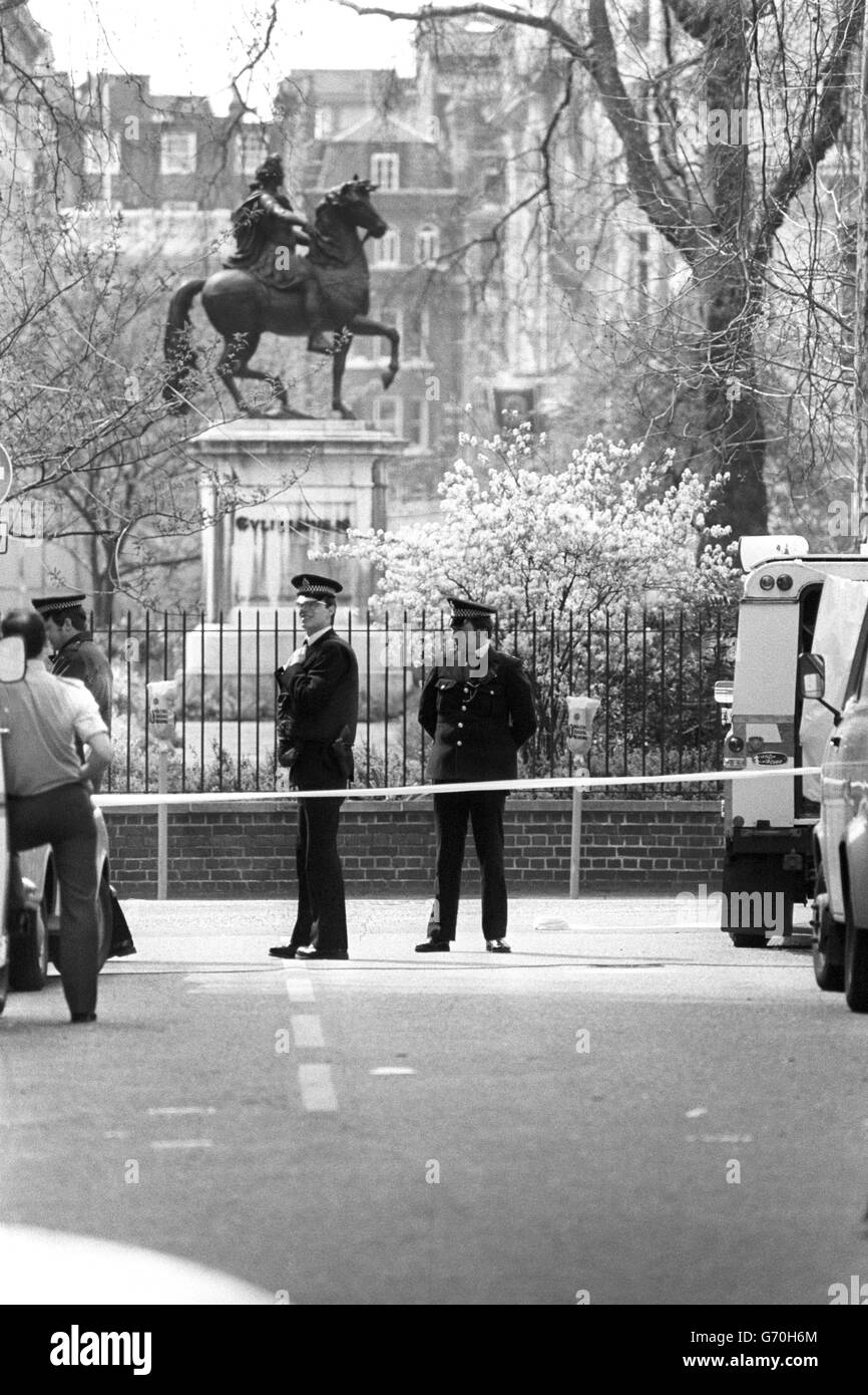 Gli ufficiali di polizia, uno con giacca in flak (r), stanno in piedi a St James's Square, Londra, mentre l'Ufficio del popolo libico rimane sotto assedio. Foto Stock